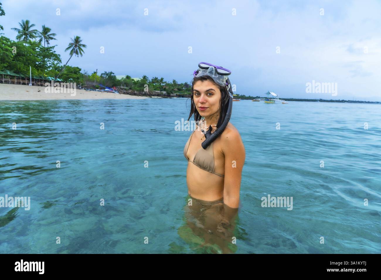 Junge Frau sNArkeling im kristallklaren Wasser des weißen Strandes, moalboal, cebu, genießen Sie die lebendigen Korallenriffe und die vielfältige Unterwasserwelt der phi Stockfoto