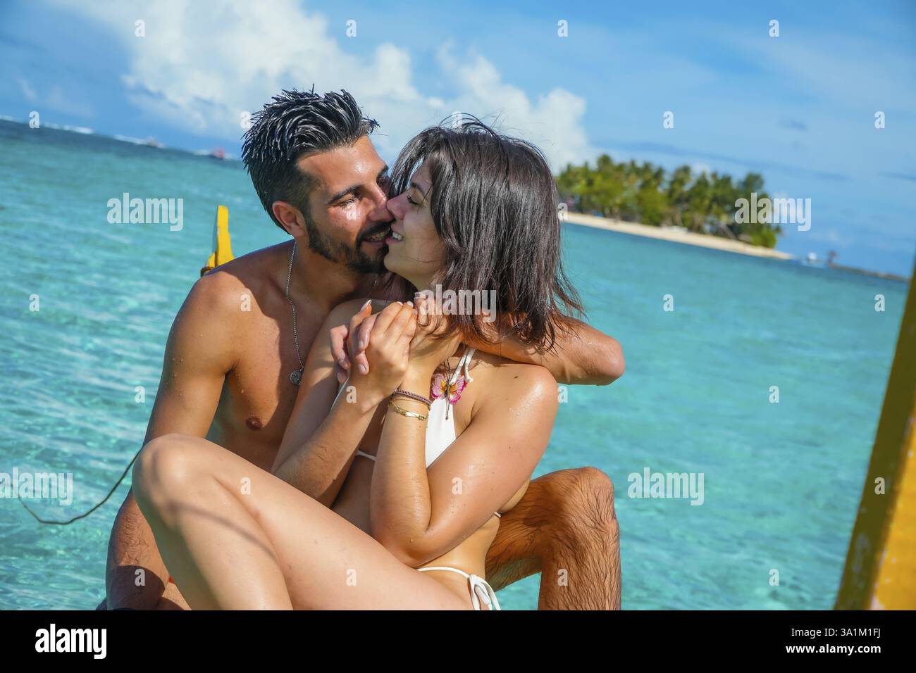 Romantisches Paar, das einen Kuss genießt, während es sich auf einem traditionellen banca-Boot im klaren türkisfarbenen Wasser der siargao-Insel auf den philippinen entspannt Stockfoto