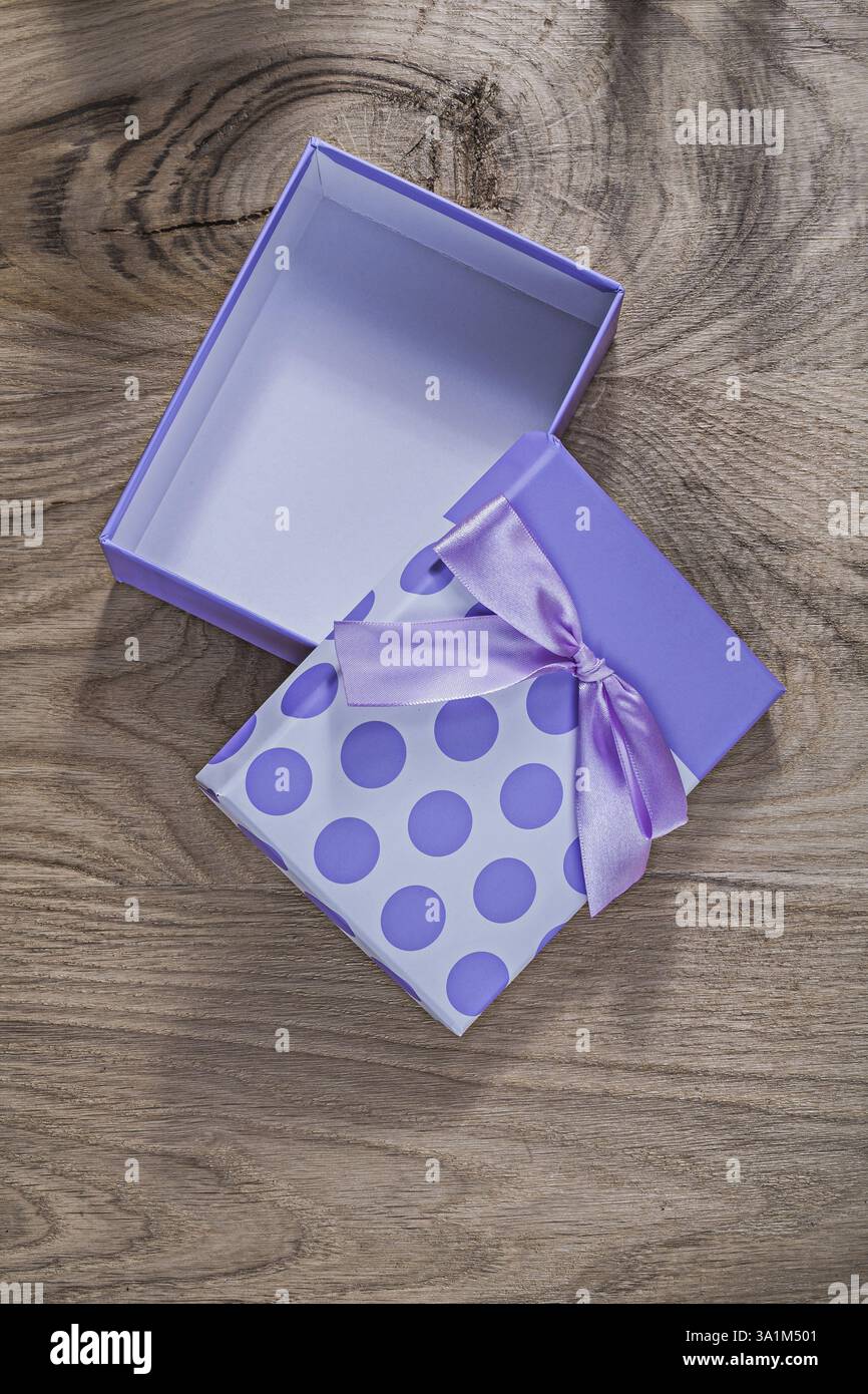 Lila geöffnete Geschenkbox mit Band auf Holzbrett Festkonzept Stockfoto