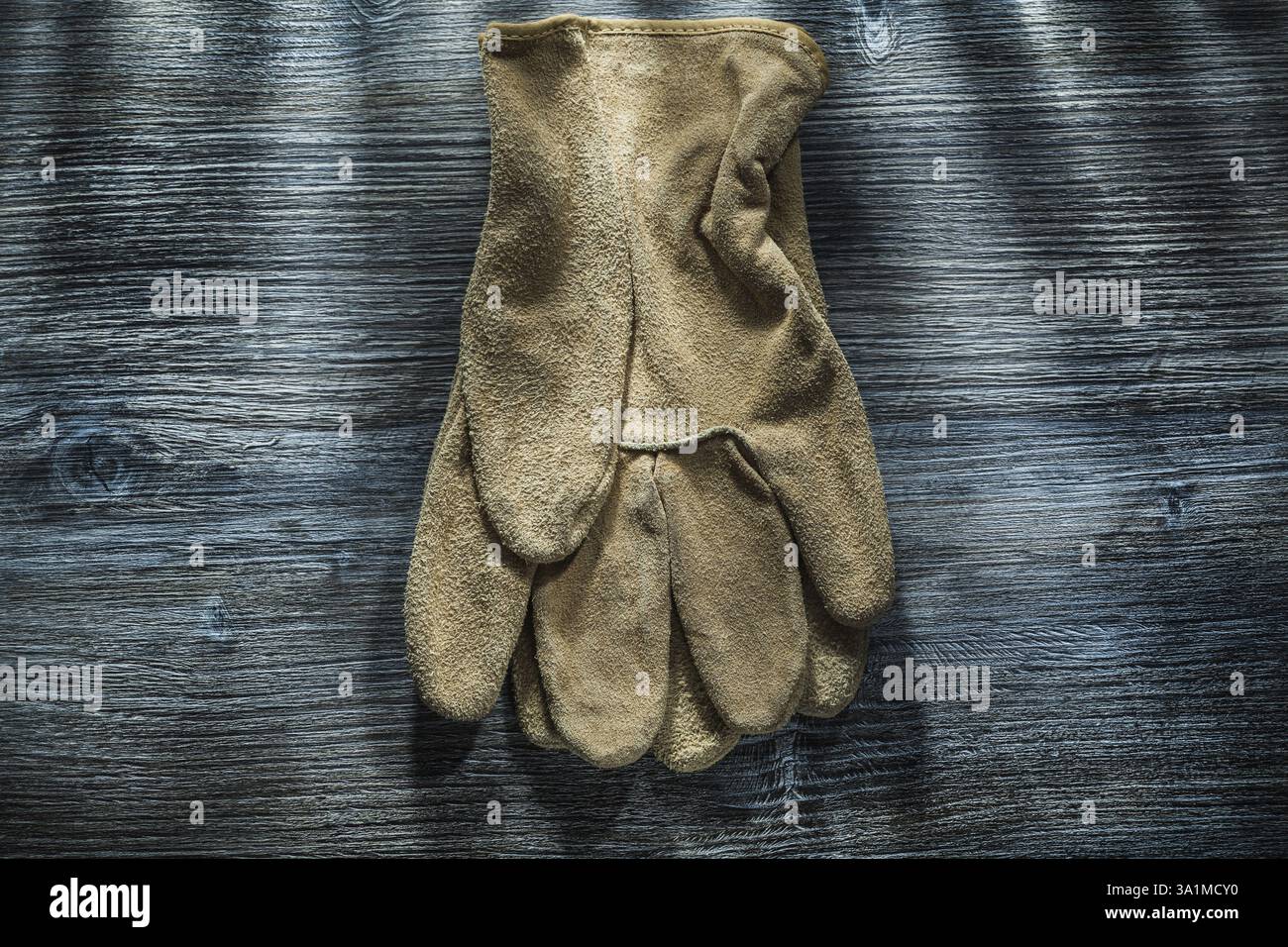 Schutzhandschuhe auf Holzbrett Stockfoto Schutzhandschuhe auf Holzbrett Stockfoto