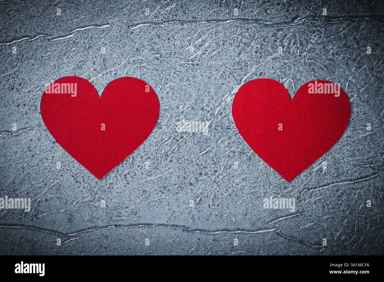 Rote Papierherzen auf metallischem Hintergrund direkt über der Valentinskarte Stockfoto