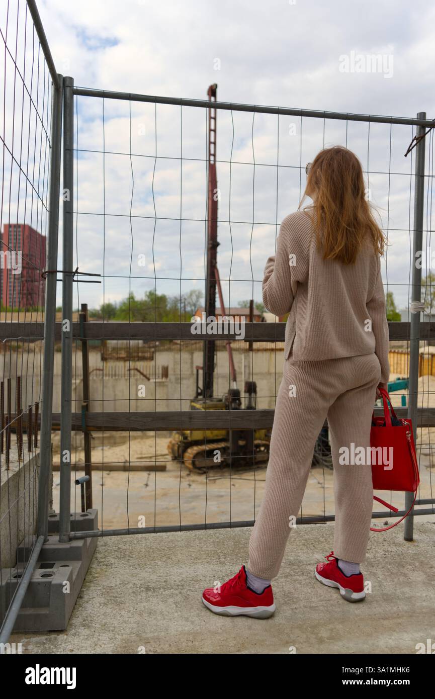 Eine Person beobachtet eine Baustelle mit aktiven Bodenarbeiten und Ausschachtungen Stockfoto