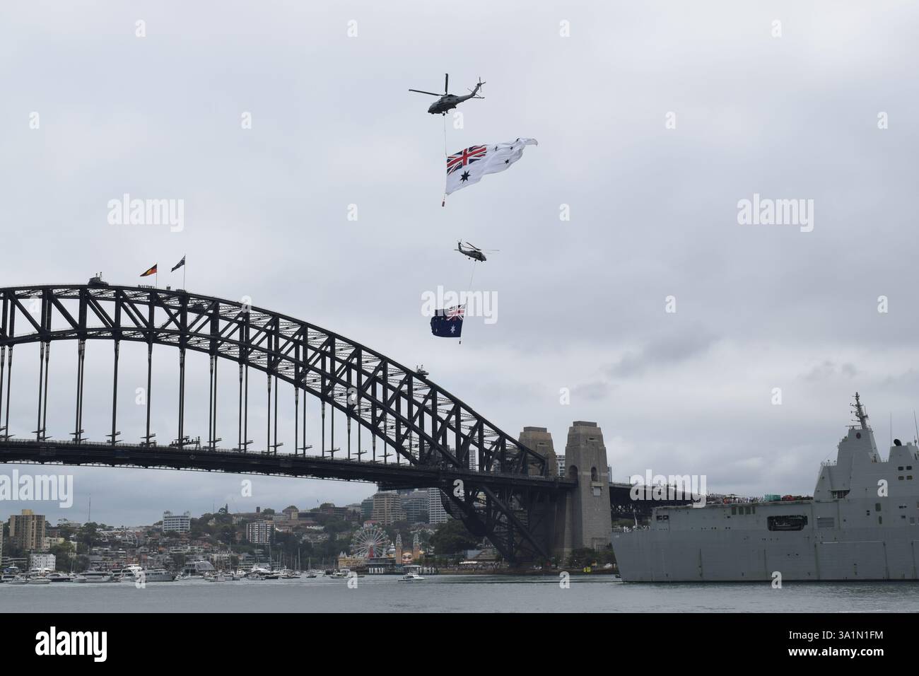Ein Helikopter der australischen Armee trägt Nationalflaggen über der berühmten Sydney Harbour Bridge und feiert den australischen Nationalfeiertag mit patriotischem Stolz Stockfoto