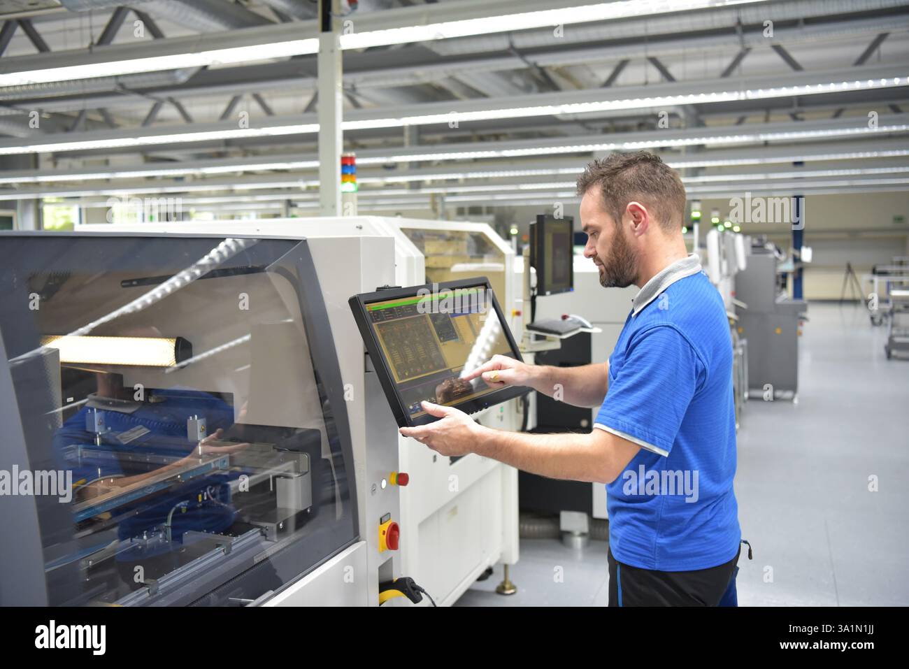 Engineering in der Mikroelektronik: Arbeiter in der Produktion und Montage von elektronischen High-Tech-Komponenten in ein modernes Werk Stockfoto