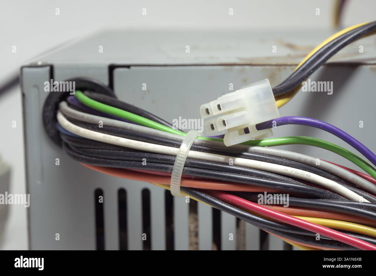 Nicht modulares ATX-Netzteil auf der Vorderseite des Computers. Veraltete Netzanschlüsse von PC-Laufwerken und Mainboard. Stromanschlüsse für Laufwerke, verbunden mit einem Stockfoto