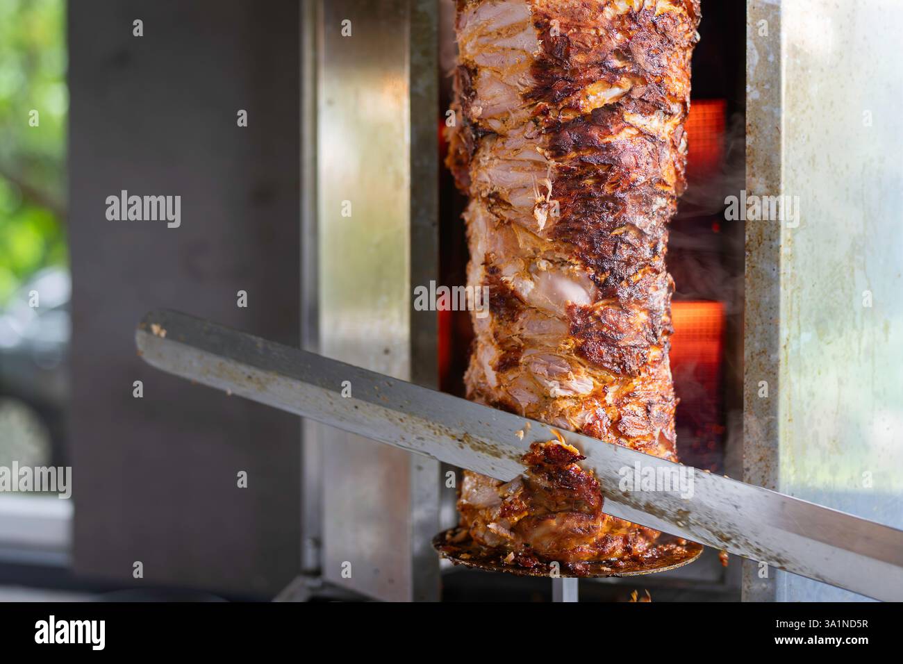 Der Koch bereitet traditionelles türkisches Dönerfleisch zu. Gegrilltes Fleisch für die Herstellung eines traditionellen türkischen Essens Döner Kebab oder griechischer Gyros. Stockfoto