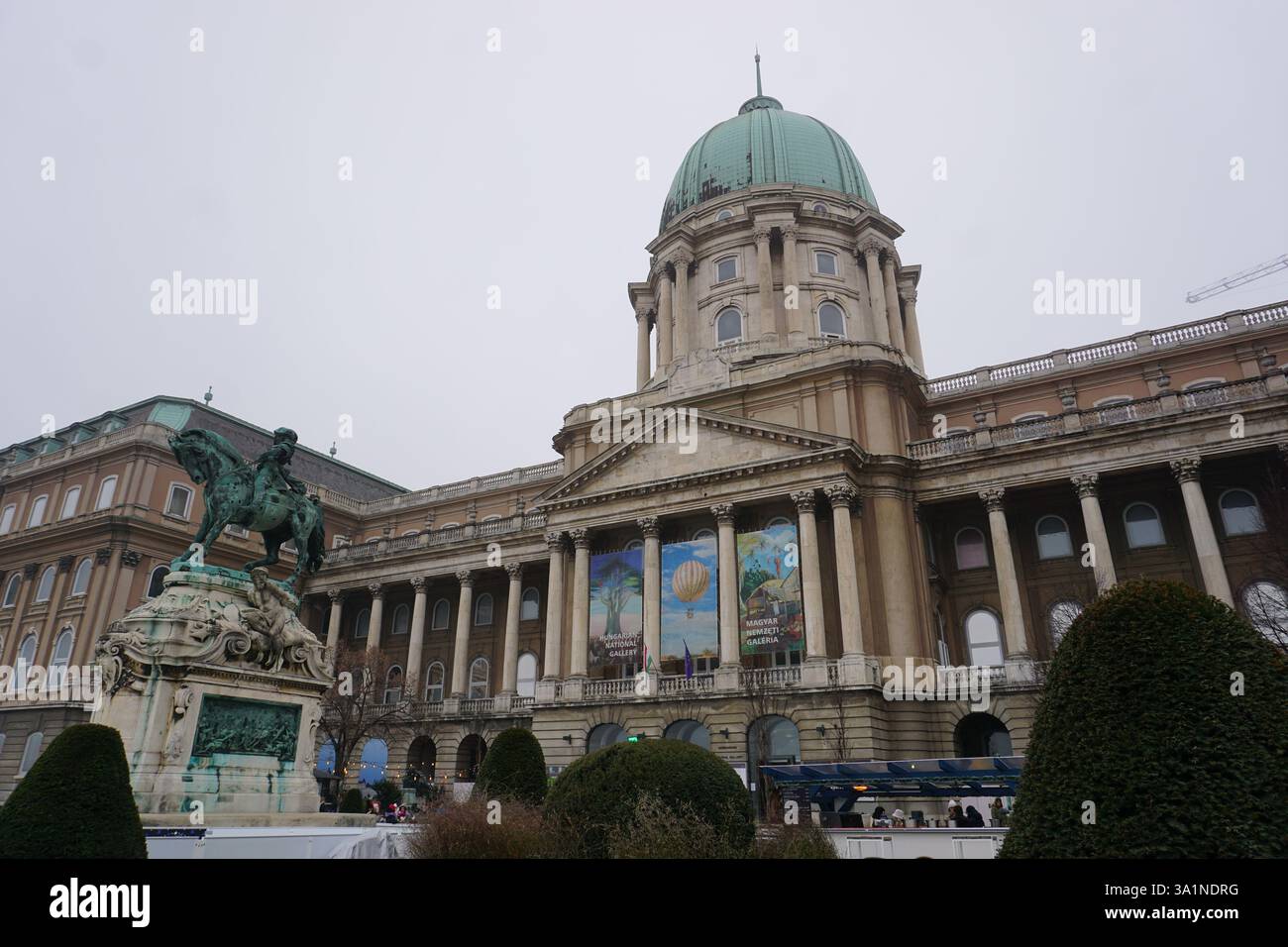 Frontalblick auf das Schloss Buda und die ungarische Nationalgalerie mit der Wahrzeichen der Statue des Prinzen Eugen von Savoyen an einem nebeligen Wintertag Stockfoto