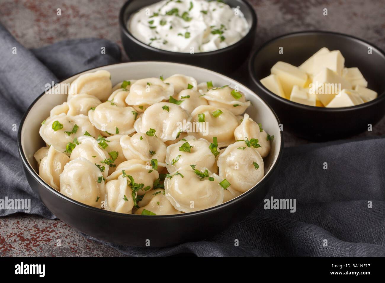 Hausgemachte Fleischklöße oder Pelmeni mit frischer Petersilie auf Teller Nahaufnahme auf dem Tisch. Horizontal Stockfoto
