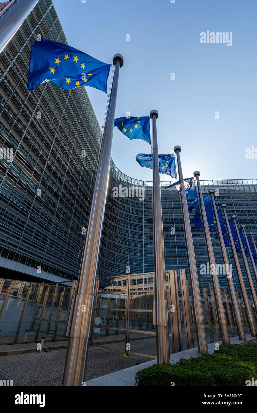 Europäische Fahnen, Symbole der Europäischen Union (EU), flattern gegen das Berlaymont-Gebäude, Sitz der Europäischen Kommission in Brüssel Stockfoto