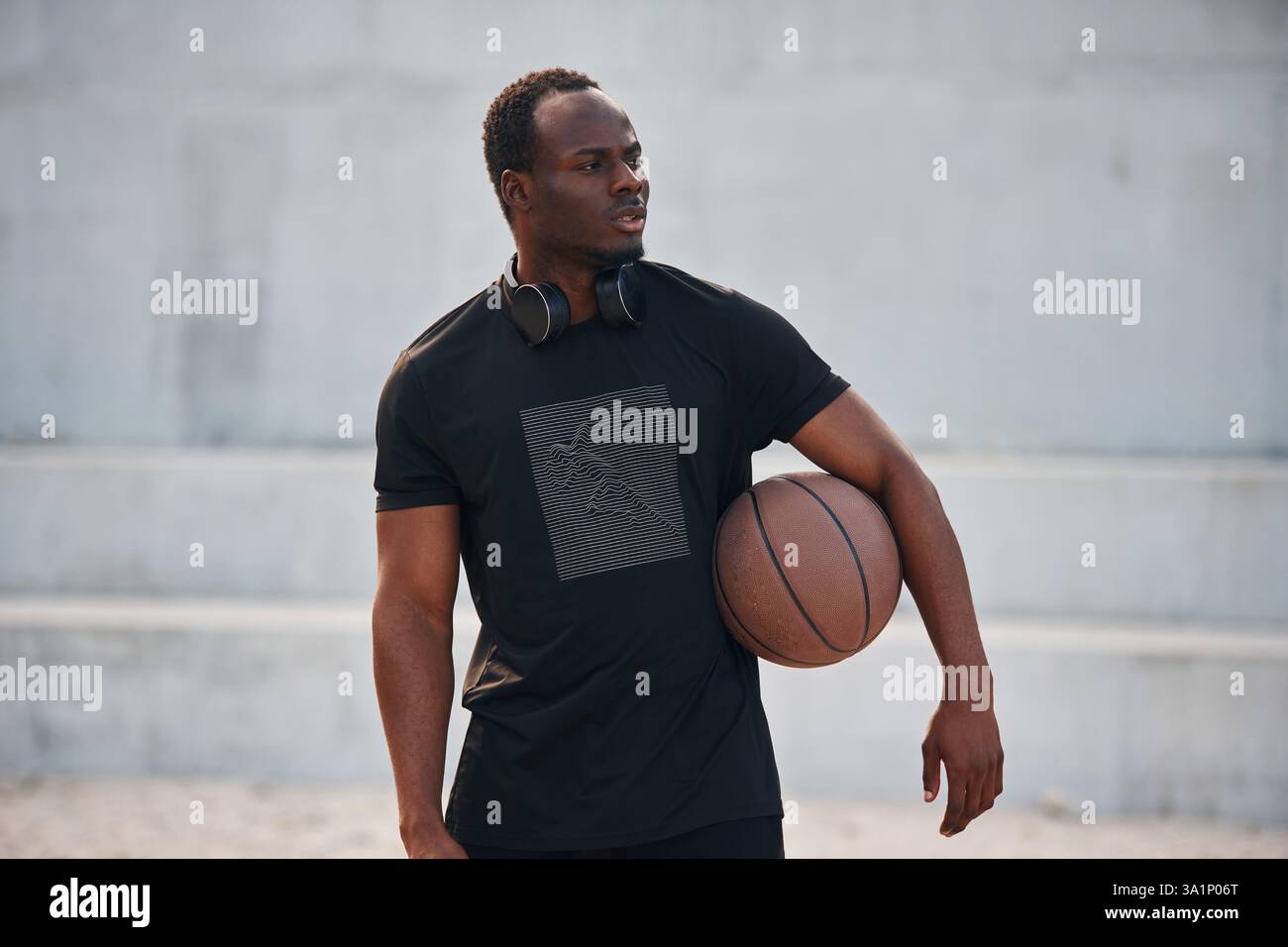 Den Ball in den Händen halten. Junger schwarzer Mann. Stockfoto
