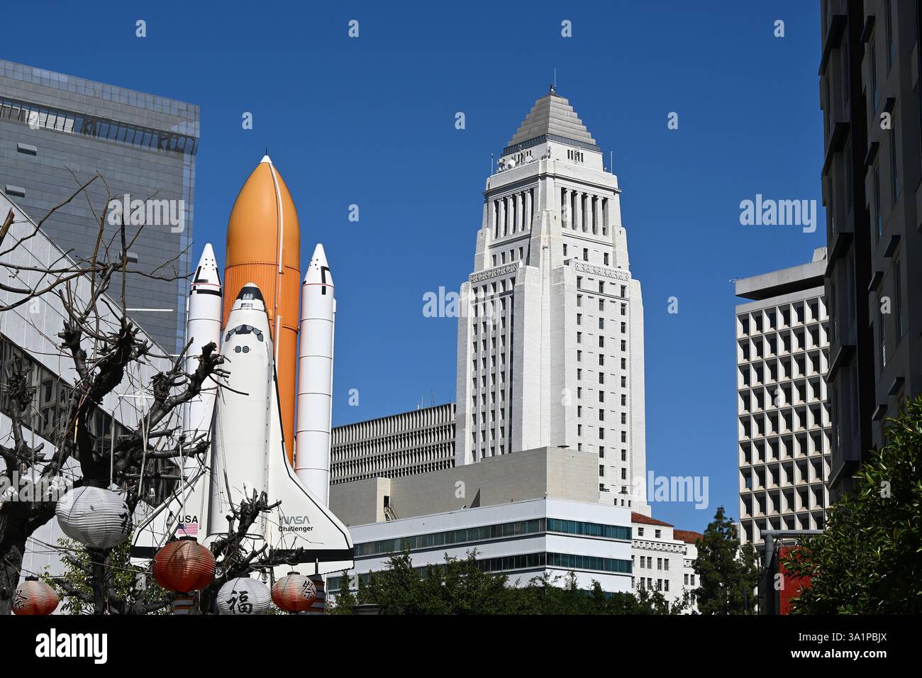 LOS ANGELES, KALIFORNIEN - 8. März 2025: Das Space Shuttle Challenger Monument in Little Tokyo, mit dem Rathaus im Hintergrund. Stockfoto