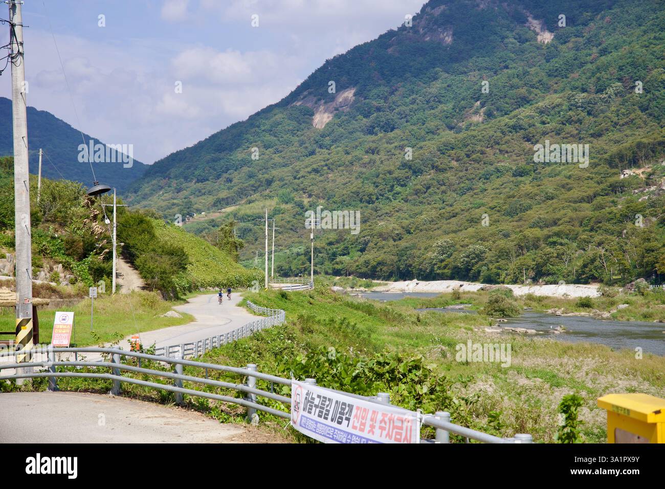 Sunchang County, Südkorea - 4. Oktober 2021: Ein landschaftlich reizvoller Abschnitt des Seomjingang Bike Path schlängelt sich entlang des Seomjin River, während Radfahrer Agave fahren Stockfoto