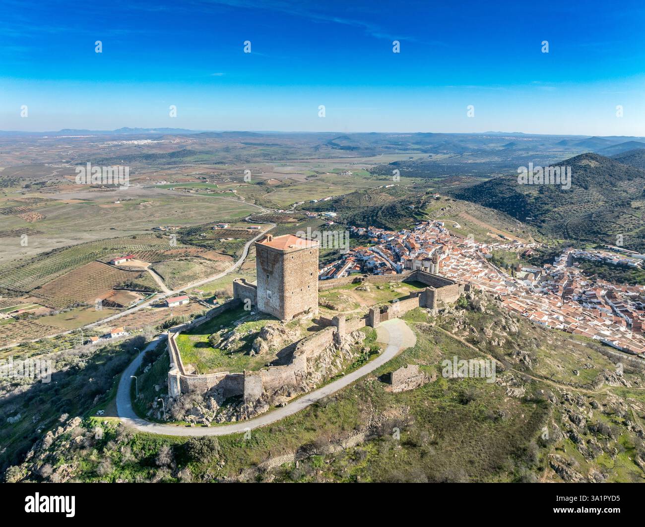 Aus der Vogelperspektive auf das Schloss Feria in Spanien, gotische und Mudéjar-Gebäude, einen quadratischen Donjon, einen Hintergrund mit blauem Himmel Stockfoto