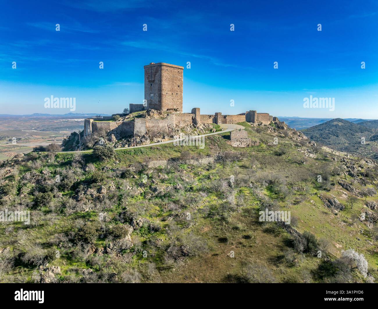 Aus der Vogelperspektive auf das Schloss Feria in Spanien, gotische und Mudéjar-Gebäude, einen quadratischen Donjon, einen Hintergrund mit blauem Himmel Stockfoto