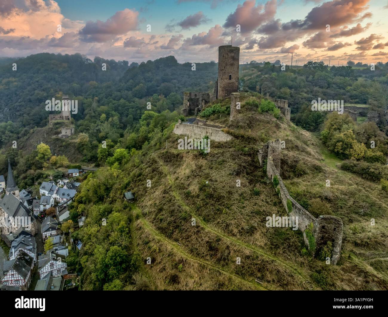 Aus der Vogelperspektive der Zwillingsburgen Philippsburg und Löwenburg über Monreal in Deutschland mit hohem Sonnenuntergangshimmel Stockfoto