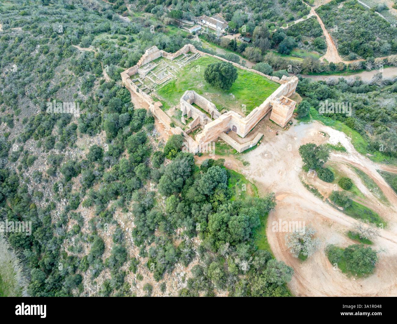 Steinmauern und Zinnen prägen die mittelalterliche Architektur der Burg Paderne, eine historische portugiesische Festung vor einem blauen Himmel Stockfoto
