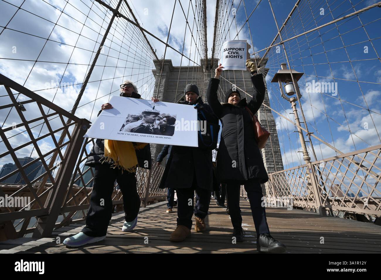 New York, USA. März 2025. Menschen nehmen an einem bürgerrechtsmarsch über die Brooklyn Bridge Teil, zu Ehren des 60. Jahrestages des „Bloody Sunday“, New York, NY, 9. März 2025. Am 7. März 1965 wurden Bürgerrechtsaktivisten, die gegen die Segregation im Süden protestierten, von Staatstruppen aus Alabama angegriffen, nachdem sie die Edmund Pettus Bridge in Selma, Alabama, überquerten. (Foto: Anthony Behar/SipaUSA) Credit: SIPA USA/Alamy Live News Stockfoto