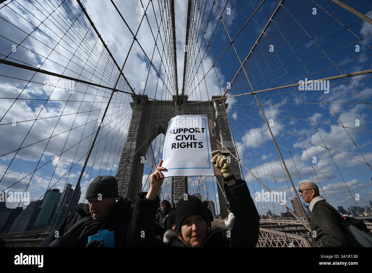 New York, USA. März 2025. Menschen nehmen an einem bürgerrechtsmarsch über die Brooklyn Bridge Teil, zu Ehren des 60. Jahrestages des „Bloody Sunday“, New York, NY, 9. März 2025. Am 7. März 1965 wurden Bürgerrechtsaktivisten, die gegen die Segregation im Süden protestierten, von Staatstruppen aus Alabama angegriffen, nachdem sie die Edmund Pettus Bridge in Selma, Alabama, überquerten. (Foto: Anthony Behar/SipaUSA) Credit: SIPA USA/Alamy Live News Stockfoto