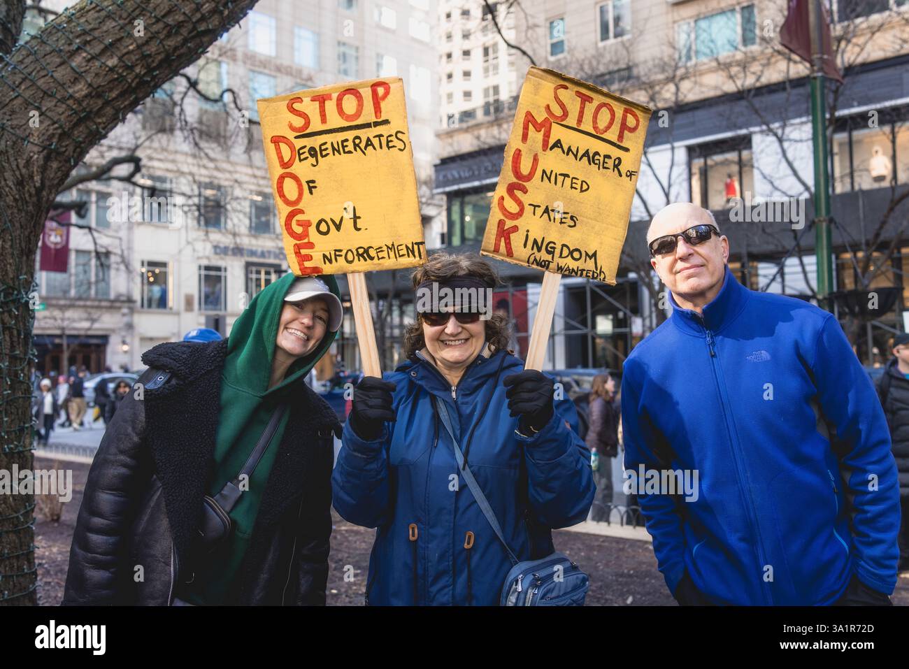 Chicago, USA. März 2025. Organisiert von mehreren Gruppen, darunter unteilbare Chicago, versammelten sich Demonstranten in der Innenstadt von Chicago und marschierten gegen die Politik von Elon Musk und Präsident Donald Trump ein. Nach Verhandlungen mit der Polizei von Chicago durften die Demonstranten zum Telsa-Händler in der Rush Street marschieren. Hunderte sangen vor den Türen von Tesla gegen Musk und DOGE. Quelle: JankPhoto/Alamy Live News. Stockfoto