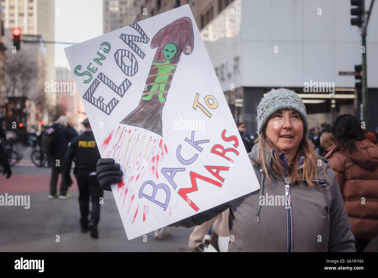 Chicago, USA. März 2025. Organisiert von mehreren Gruppen, darunter unteilbare Chicago, versammelten sich Demonstranten in der Innenstadt von Chicago und marschierten gegen die Politik von Elon Musk und Präsident Donald Trump ein. Nach Verhandlungen mit der Polizei von Chicago durften die Demonstranten zum Telsa-Händler in der Rush Street marschieren. Hunderte sangen vor den Türen von Tesla gegen Musk und DOGE. Quelle: JankPhoto/Alamy Live News. Stockfoto