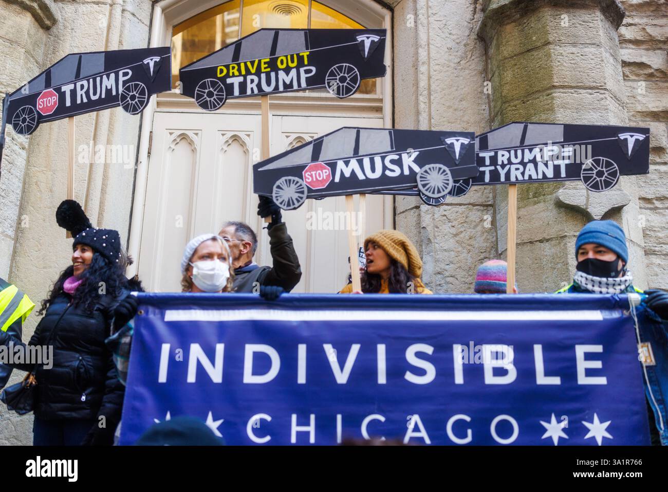 Chicago, USA. März 2025. Organisiert von mehreren Gruppen, darunter unteilbare Chicago, versammelten sich Demonstranten in der Innenstadt von Chicago und marschierten gegen die Politik von Elon Musk und Präsident Donald Trump ein. Nach Verhandlungen mit der Polizei von Chicago durften die Demonstranten zum Telsa-Händler in der Rush Street marschieren. Hunderte sangen vor den Türen von Tesla gegen Musk und DOGE. Quelle: JankPhoto/Alamy Live News. Stockfoto