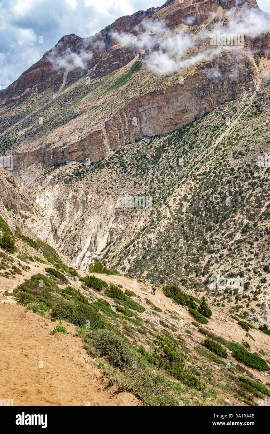 Auf dem Weg zum ruhigen Dorf Nar, Nepal, in den Bergen des Himalaya, eingerahmt von nebelhaften zerklüfteten Gipfeln. Stockfoto