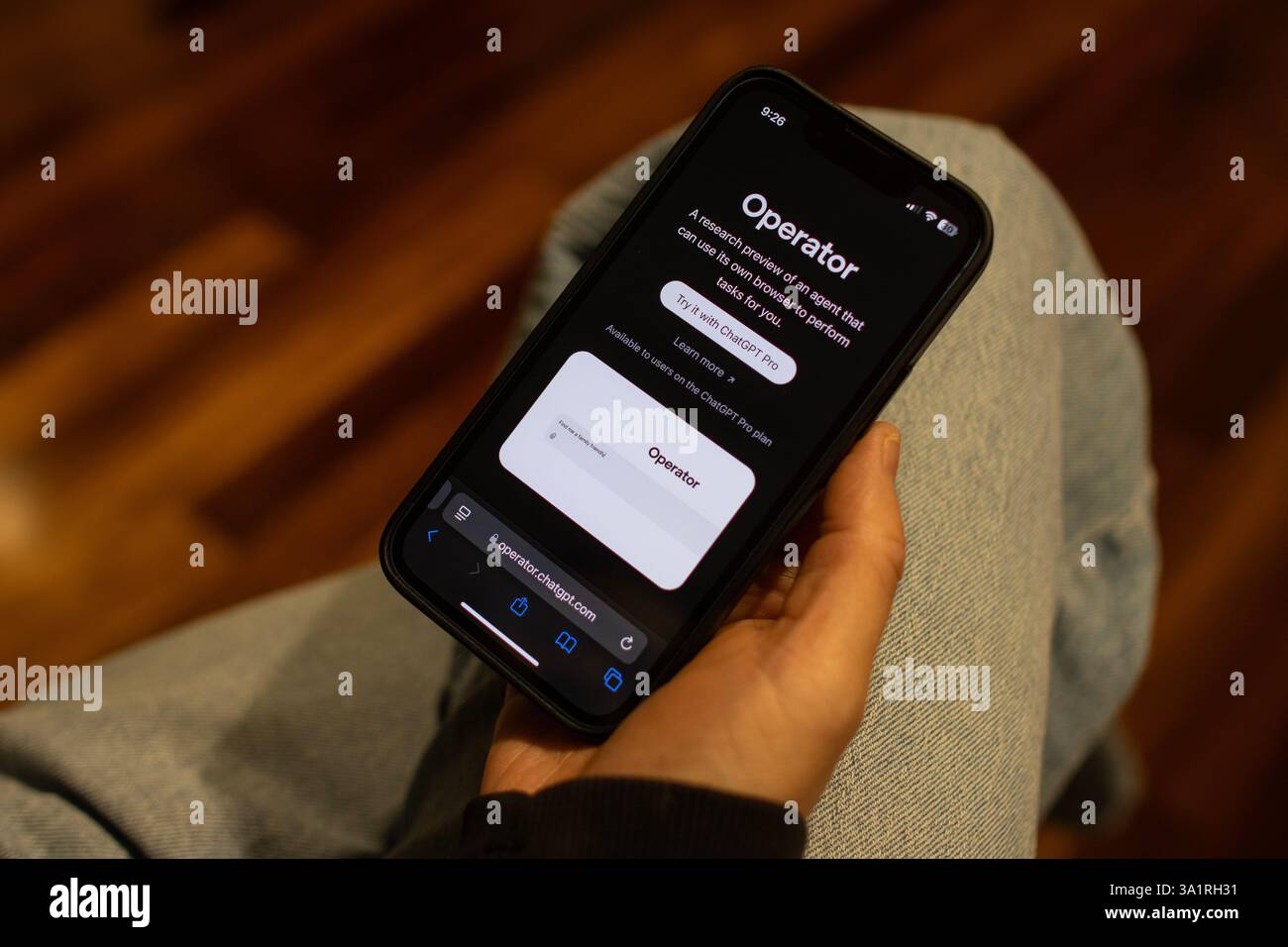 Ein iPhone-Benutzer durchsucht die Webseite von OpenAI's Operator, einem AI-Agenten, der Aufgaben im Web für Benutzer ausführen kann, am Sonntag, den 9. März 2025. Stockfoto