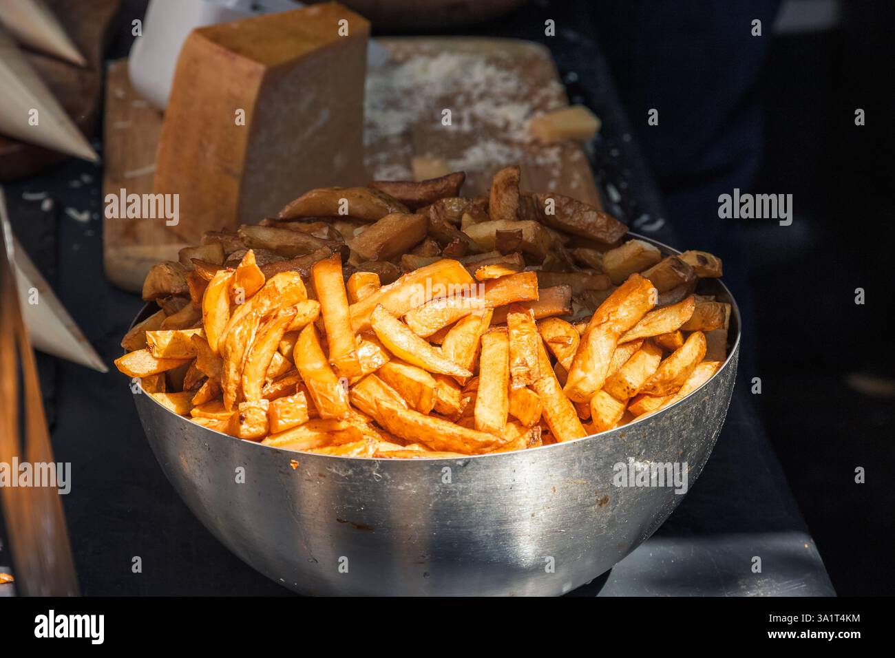 Goldene Chips in einer Schüssel auf dem Brick Lane Market in London Stockfoto