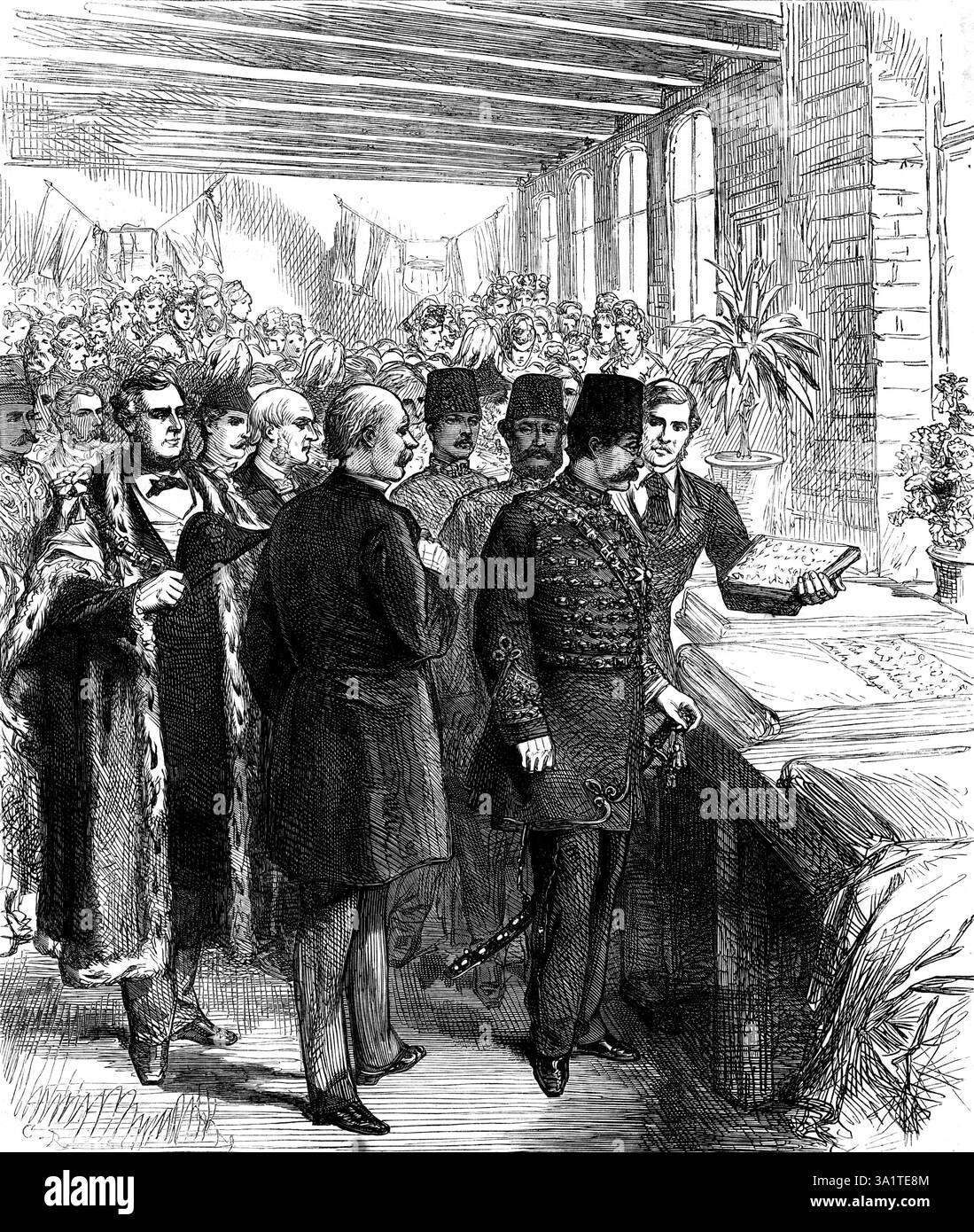 The Shah at Manchester: Inspektion eines mit persischen Willkommensworten gedruckten Kalikos, 1873. Seine Majesty...set nach Salford, um die Baumwollfabriken von Messrs. Haworth und Co. Zu sehen... sah er die Baumwolle in allen Phasen, von der Vorbereitung des Rohstoffs bis zum Weben. Er wurde in den Raum geführt, in dem sich das riesige Schwungrad der Maschine dreht; der längste Aufenthalt wurde jedoch im Webraum gemacht, wo 1100 Rahmen voll in Betrieb waren. Der Schah schien hier mehr Interesse zu haben als an jedem anderen Teil, denn hier wird das Material in den fertigen artikel umgewandelt. Er stand ein paar Stockfoto