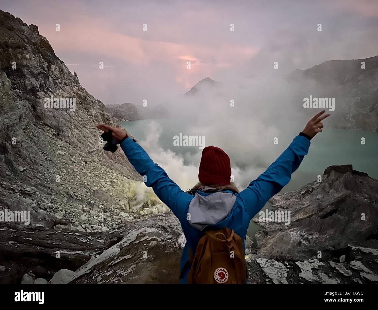 Abenteuerliches Wandermädchen in der Mondlandschaft des Mount Ijen Vulkans während des Sonnenaufgangs - Smartphone-aufgenommenes Stockfoto