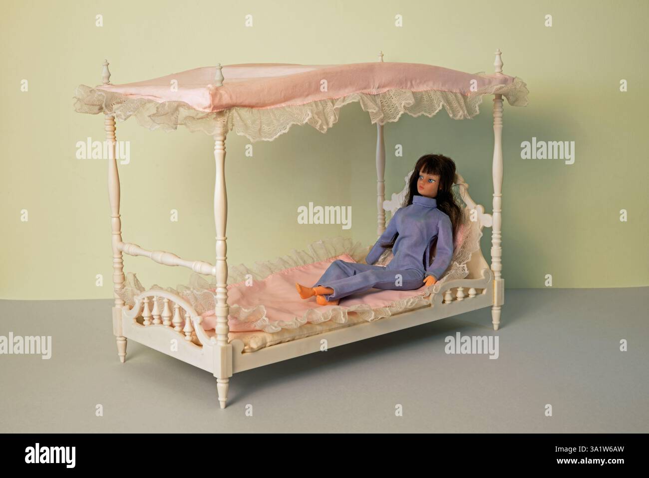 1970er Jahre Action Girl Puppe, die auf ihrem Himmelbett liegt und einen blauen Hosenanzug trägt, von Palitoy Stockfoto