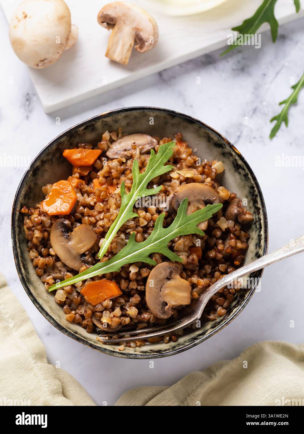 Blick von oben auf Buchweizen Brei Gericht mit Pilzen, Karotten und Salat, gesunde Ernährung Konzept Stockfoto