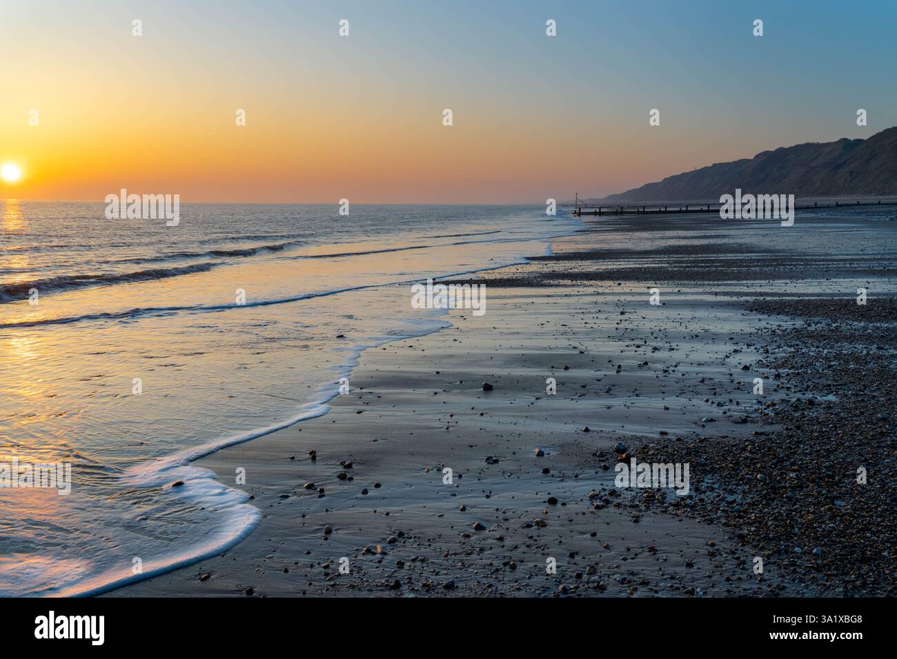 Sonnenaufgang am Strand in Mundesley, Norfolk, Großbritannien, mit Sonnenaufgang über dem Horizont Stockfoto