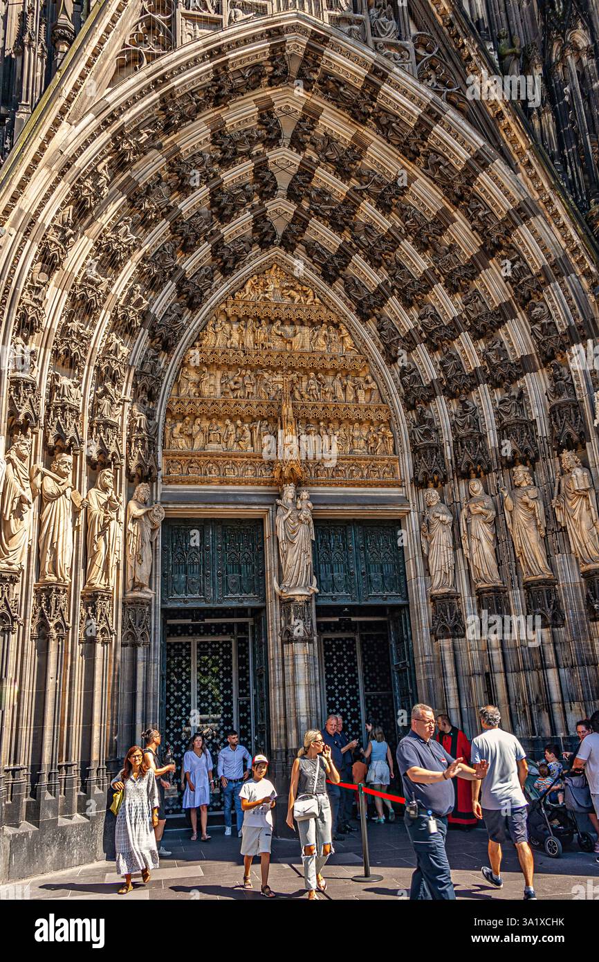 Touristen warten darauf, durch das verzierte Südportal des gotischen Kölner Doms zu kommen, das zum UNESCO-Weltkulturerbe gehört. Köln, Deutschland, Europa Stockfoto