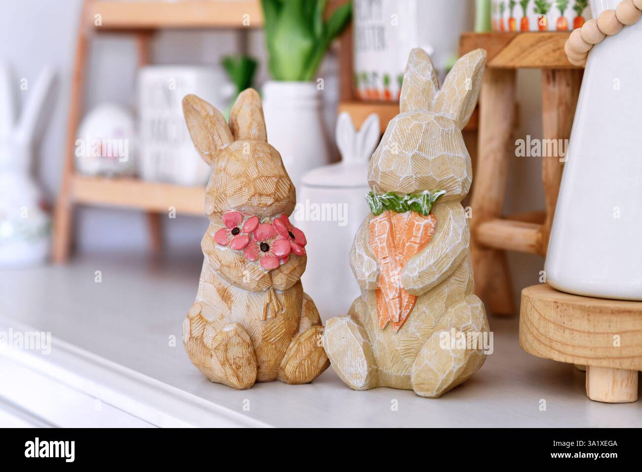 Ein paar süße rustikale Osterhasen-Dekoration mit Blumen und Karotten Stockfoto