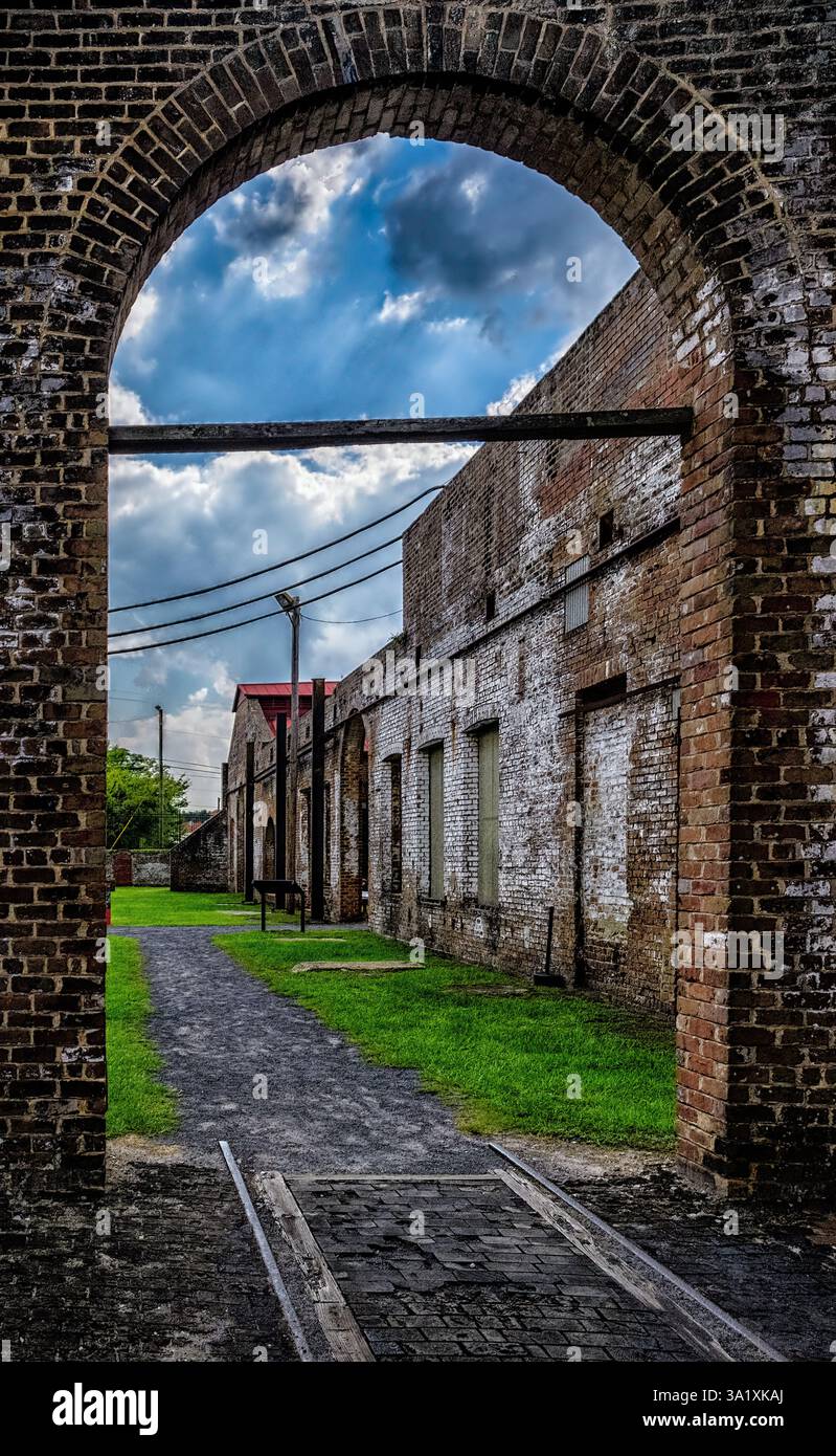 Rote Backsteinfassade des Bahnhofs durch einen Bogen im Roundhouse des Georgia State Railroad Museum in Savannah, Georgia Stockfoto