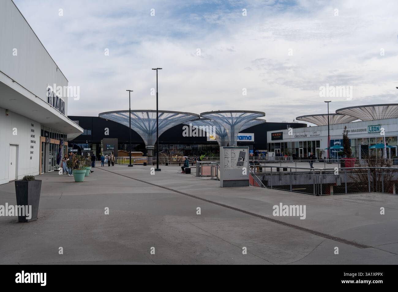 Das moderne Shopping plaza bietet einzigartige Architektur und lebhafte Geschäfte an einem bewölkten Nachmittag Stockfoto
