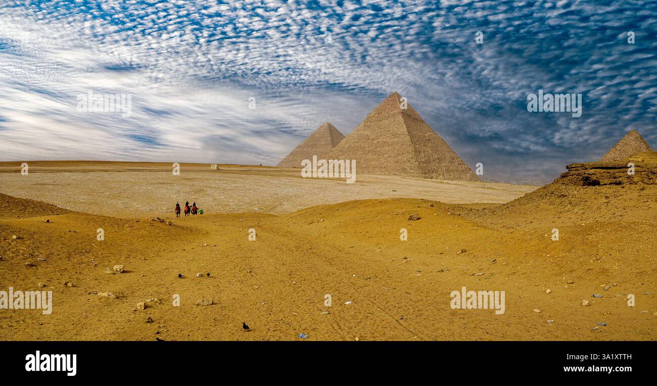 Touristen reiten Kamele in Richtung der Pyramide von Khafre auf dem Gizeh-Plateau in Ägypten Stockfoto
