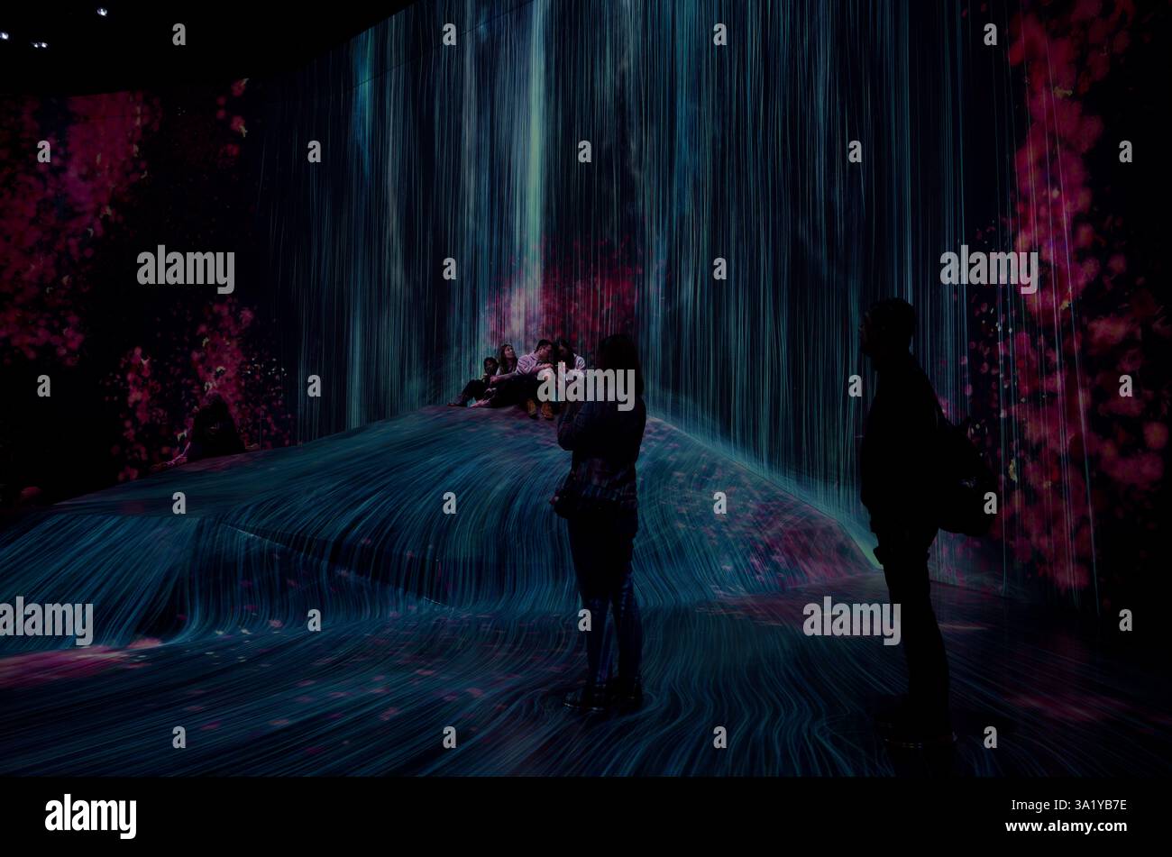 Der digitale Wasserfall kaskadiert über eine hügelige Landschaft in teamlab Borderless Stockfoto