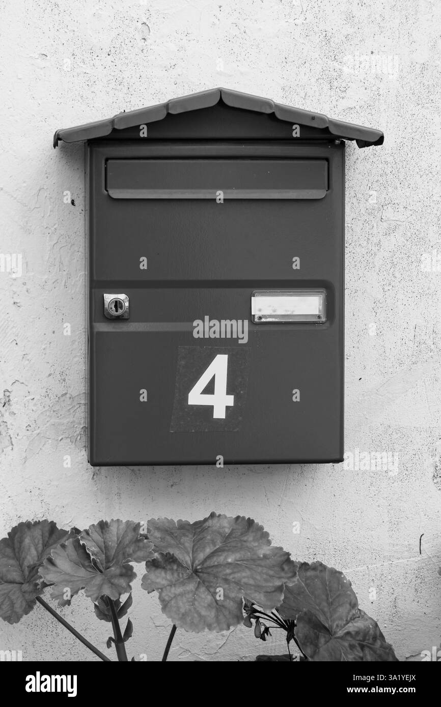Haus Nr. 4 (vier) auf Briefkasten in Schwarz-weiß Stockfoto