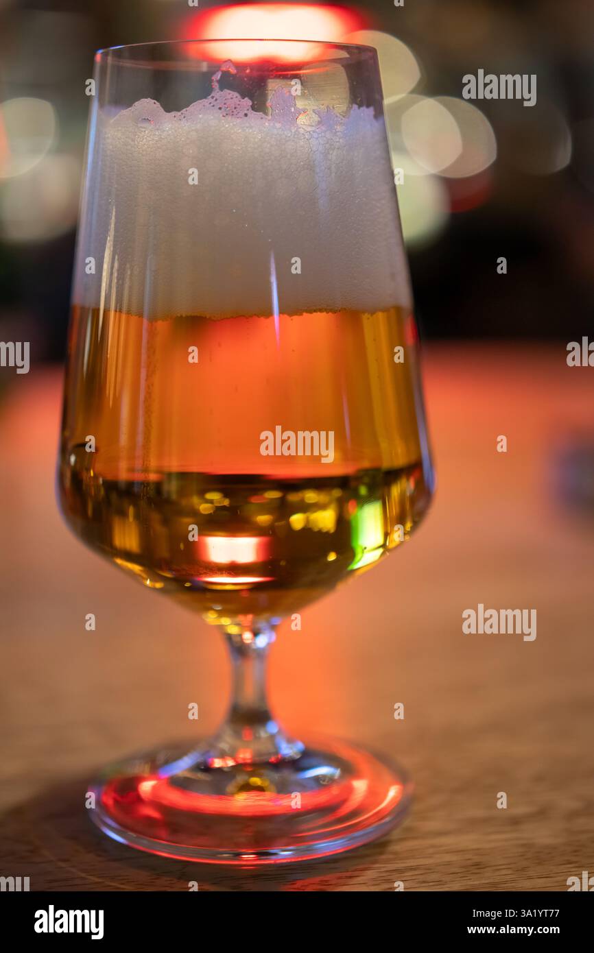 Goldenes Bier in elegantem Glas auf Holztisch Stockfoto
