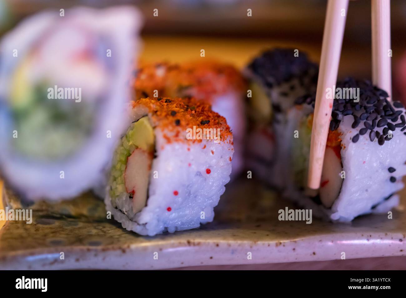 Nahaufnahme der köstlichen California Rolls mit Stäbchen Stockfoto