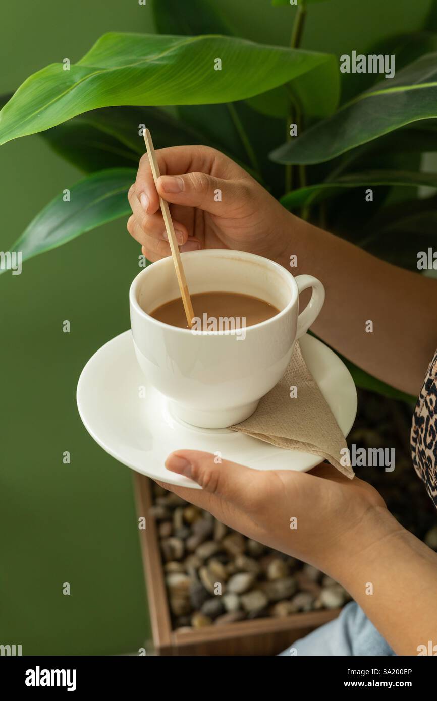 Ein warmer und einladender Moment, da ein Profi einem Kunden im Büro eine Tasse frisch gebrühten Kaffee anbietet und so einen komfortablen und einladenden geldautomaten schafft Stockfoto