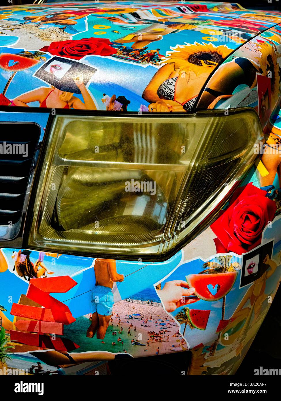 Pop-Art-Auto mit exzentrischem Collage-Design 2 Eine Nahaufnahme der Vorderseite eines Fahrzeugs, die komplett mit farbenfroher, eklektischer Collage-Kunst bedeckt ist. Die lebendige Ästheti - Smartphone-aufgenommenes Stockfoto