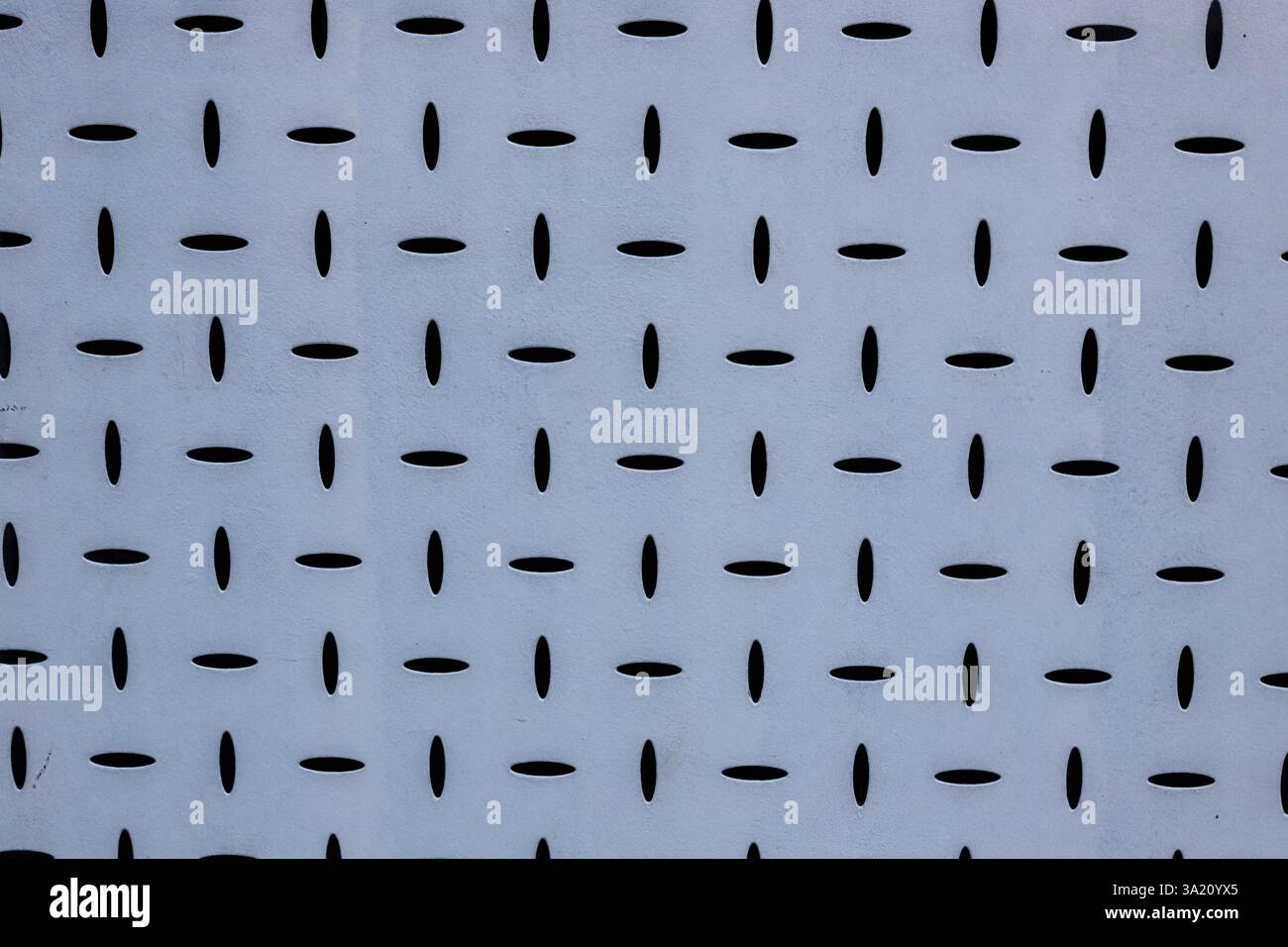 Geometrische Muster zieren die blaue Fassade eines Gebäudes in Bukarest, Rumänien, die eine Mischung aus moderner Architektur und künstlerischem Stil darstellen. Stockfoto