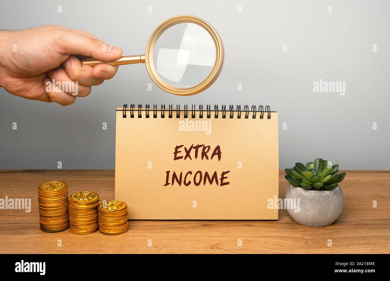 Zusatzeinkommenskonzept. Geld, das zusätzlich zu einer primären Einkommensquelle, wie einem Gehalt oder Löhnen, verdient wird. Notizbuch, Lupe und Münzen Stockfoto