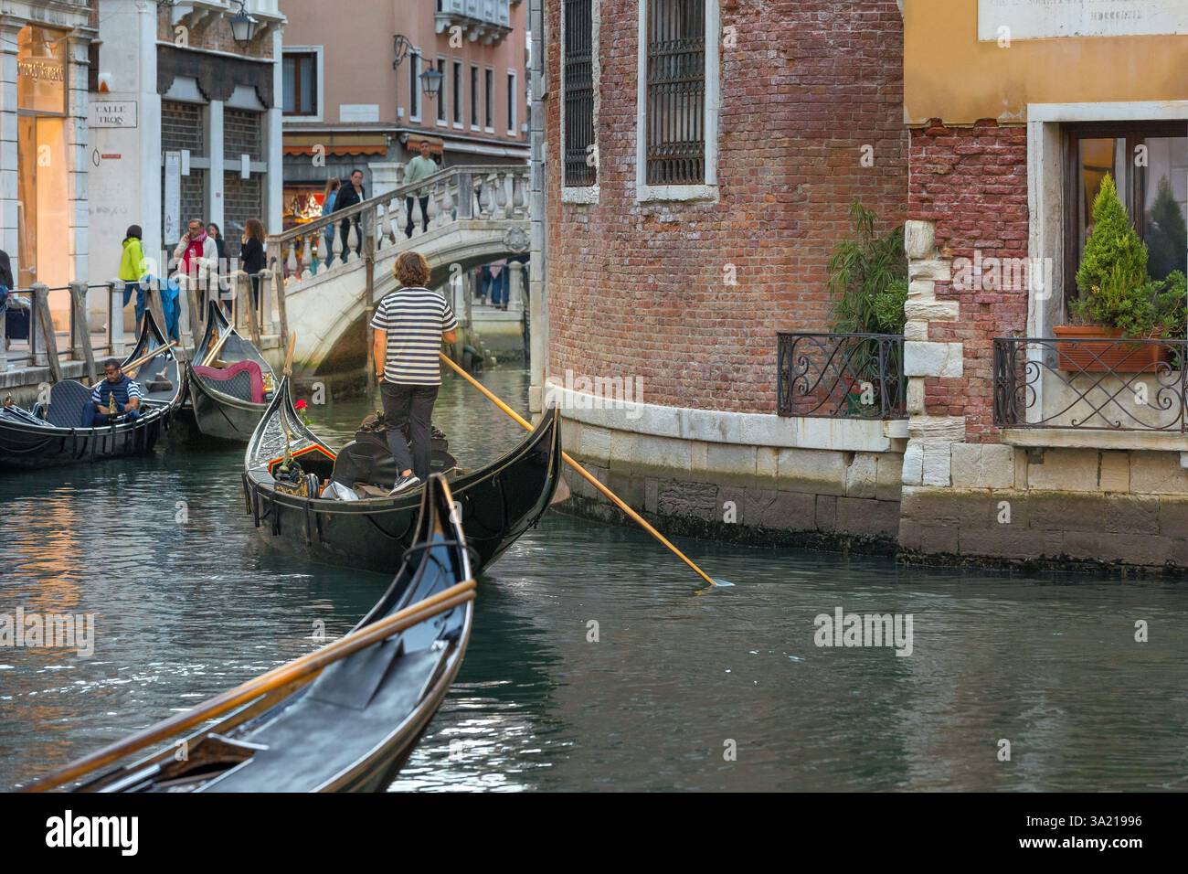 Venedig, Italien - 30. September 2024: Gondoliere in einer Gondelbahn auf dem Kanal der Altstadt, Abend Stockfoto