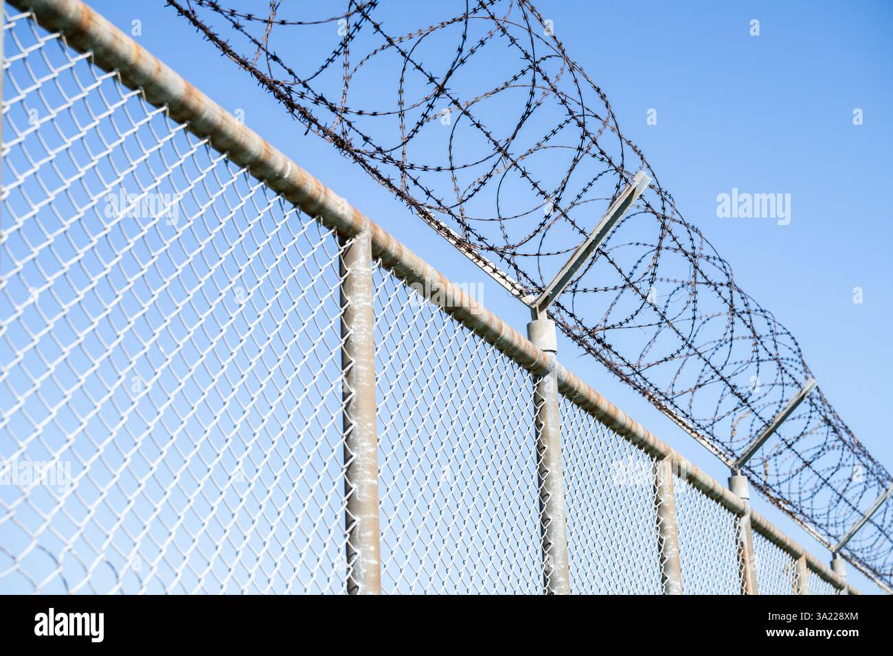 Sicherheitszaun für Gefängnisse. Sicherheitszaun mit Stacheldraht. Stacheldrahtzaun. Barrierefreiheit. Grenzschutzwand. Gefängnis für Verbrecher Stockfoto