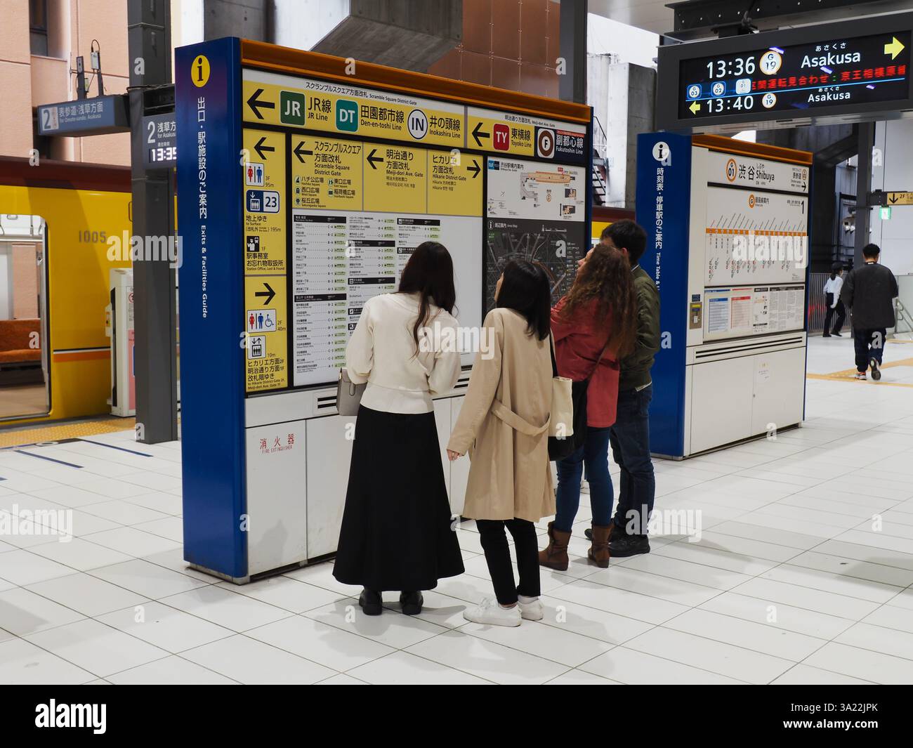 TOKIO, JAPAN - 6. November 2024: Die Leute sehen sich eine Informationstafel am Bahnsteig der Tokyo Metro Ginza Line des Bahnhofs Shibuya an. Stockfoto