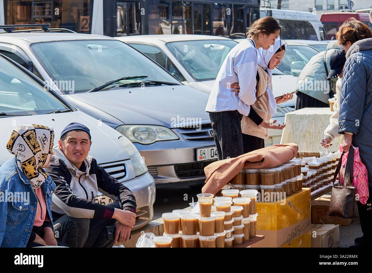 Straßenverkäufer verkaufen festliche Tafelsumalak in Plastikbehältern, Nowruz-Feier. Bischkek, Kirgisistan - 21. März 2023 Stockfoto